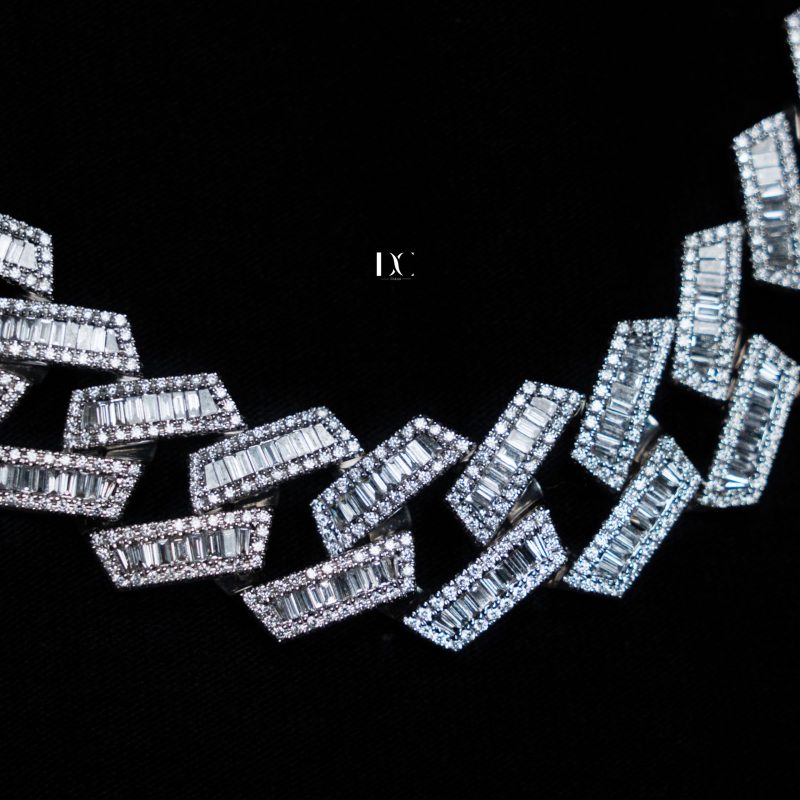 Close-up of a silver Cuban link chain with baguette diamonds, designed by DC Jewellers.